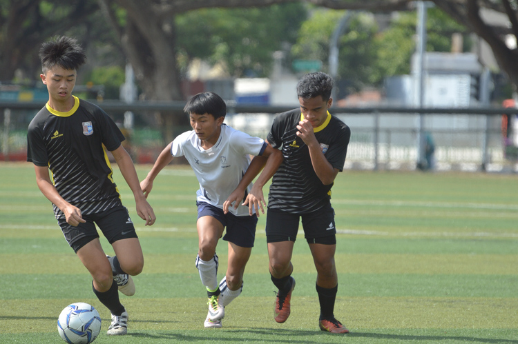 Zachary Chia (HIHS #12) battles with his opponents to get the ball. (Photo 17 © REDintern Nathiyaah Sakhimogan)
