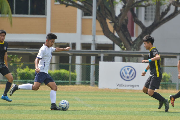 Ryan Loh (HIHS #6) attempts to cross the ball beyond the QTSS defender. (Photo 5 © REDintern Nathiyaah Sakhimogan)
