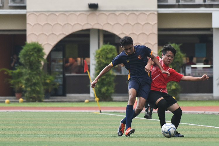 A Pioneer JC player tussles for the ball with an ACS(I) player. (Photo © Stefanus Ian/Red Sports)