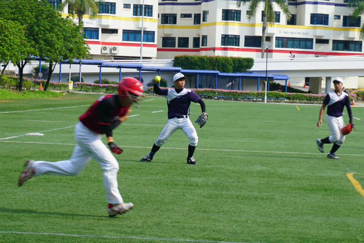 Jeremy (ACS(I) #08) (right) fielding and throwing Dao Zheng (HCI #03) (left) out at first base. (Photo 6 © REDintern Pang Chin Yee)