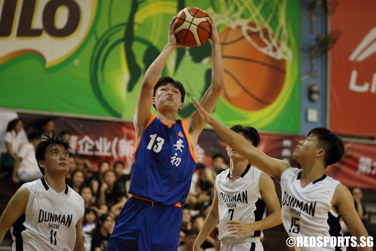 Xavier Ng (AJC #13) evades three Dunman High players for a lay-up in the paint. (Photo 8 © Dylan Chua/Red Sports)