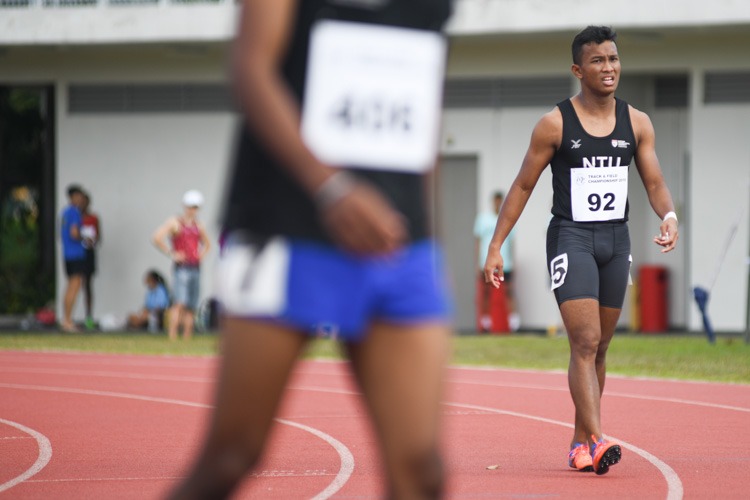 Khairyll Amri (#92) of NTU catching his breath after crossing the line first to win the IVP 100m Men's event with a time of 10.87s (Photo 1 © Stefanus Ian/Red Sports)