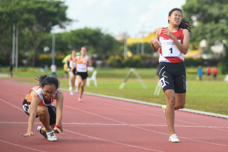 Celeste Goh of NUS (#136) falling to the ground after dipping at the finish line as Charmaine Goh of ITE (#1), who finished with a time of 1:03.38s grimaces after the Women's 400m race. (Photo 1 © Stefanus Ian/Red Sports)