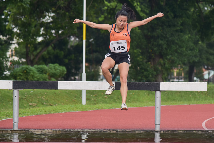 Lok Xin Ying of NUS going through the water jump as she clinched gold in the Women's 3000m Steeplechase race with a time of 13:09.91. (Photo 1 © Iman Hashim/Red Sports)
