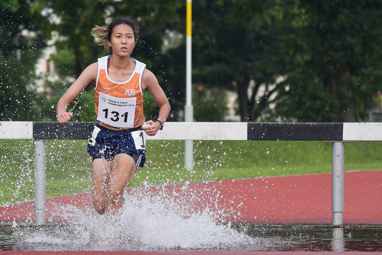 Isabella Cheong of NUS going through the water jump as she clinched silver in the Women's 3000m Steeplechase race with a time of 14:12.70. (Photo 1 © Iman Hashim/Red Sports)