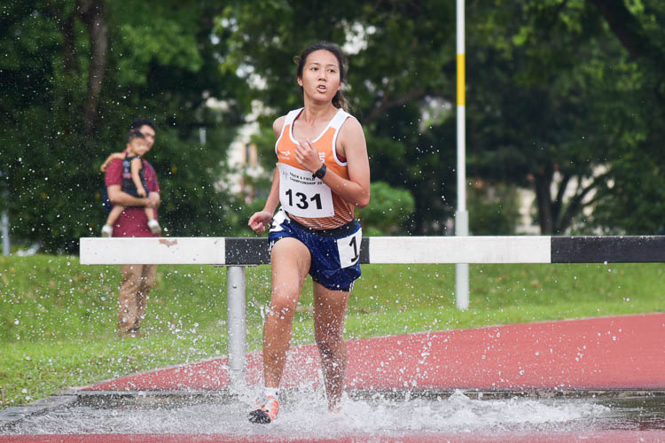 Isabella Cheong of NUS going through the water jump as she clinched silver in the Women's 3000m Steeplechase race with a time of 14:12.70. (Photo 1 © Iman Hashim/Red Sports)