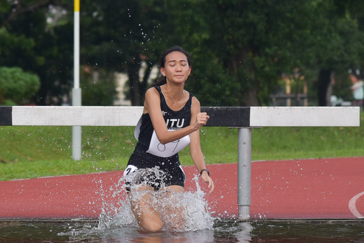 Wu Yu Han of NTU going through the water jump as she clinched bronze in the Women's 3000m Steeplechase race with a time of 14:55.03. (Photo 1 © Iman Hashim/Red Sports)