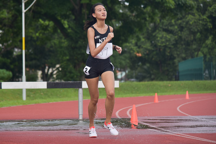 Wu Yu Han of NTU going through the water jump as she clinched bronze in the Women's 3000m Steeplechase race with a time of 14:55.03. (Photo 1 © Iman Hashim/Red Sports)