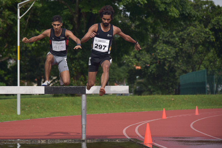Nabin Parajuli of SIM (#297) and Karthic Harish of SUTD (#415) going through the water jump during the Men's 3000m Steeplechase race. They finished in the top two positions with a time of 9:44.04 and 10:18.99 respectively. (Photo 1 © Iman Hashim/Red Sports)