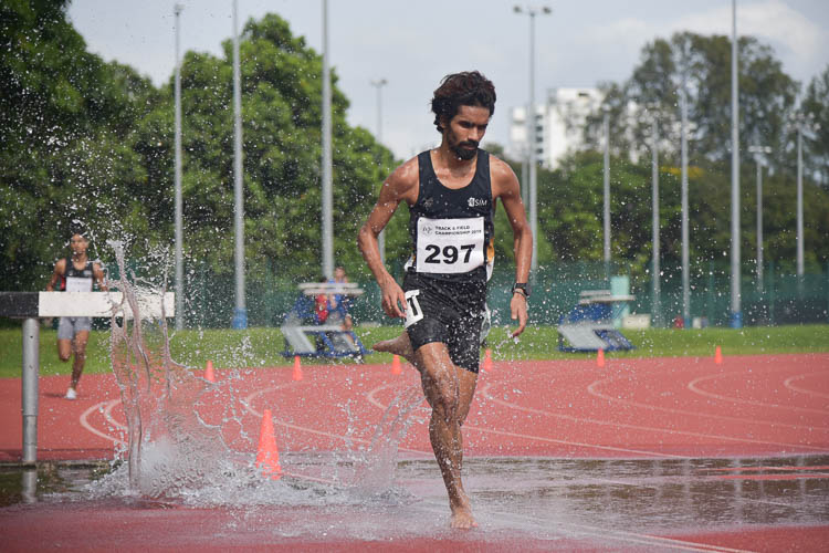 Nabin Parajuli of SIM (#297) going through the water jump during the Men's 3000m Steeplechase race. He clinched gold with a time of 9:44.04. (Photo 1 © Iman Hashim/Red Sports)