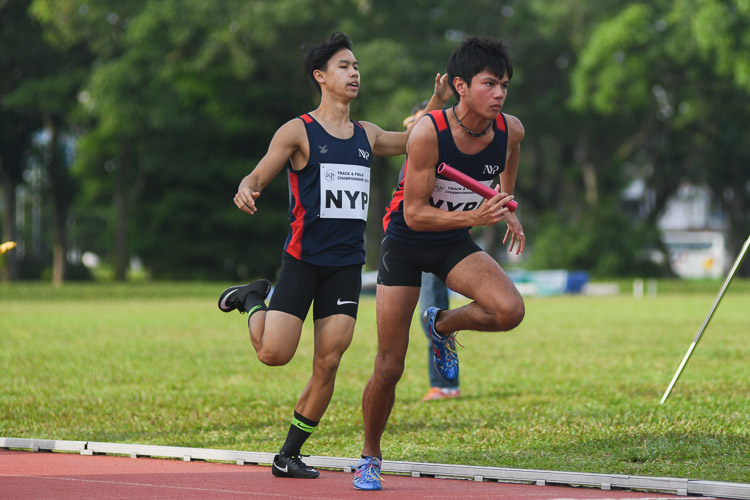 Ian Matthew Ngui of NYP passes the baton over to teammate Russell Hari Chandra in the second men's 4x400m relay timed final. (Photo 25 © Stefanus Ian/Red Sports)