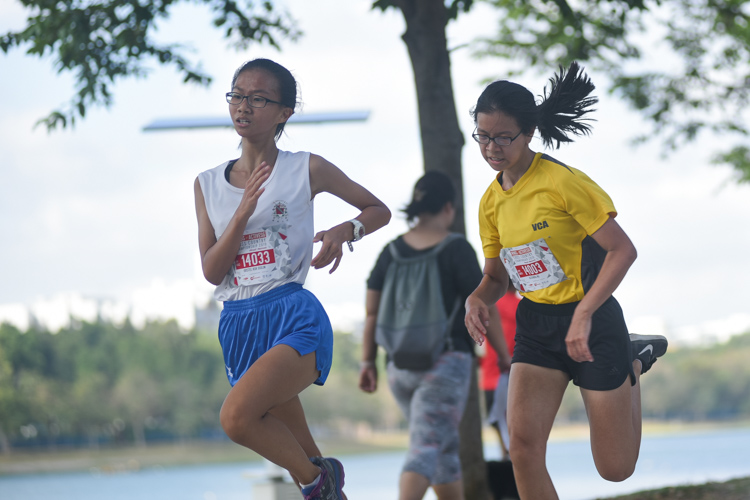 Kristel Koh (left, #14033) of CHIJ St. Nicholas Girls' School placed 11th while Alexandra Ng (#14003) of Cedar Girls’ Secondary placed 10th in the U14 Girls' race. (Photo 1 © Iman Hashim/Red Sports)