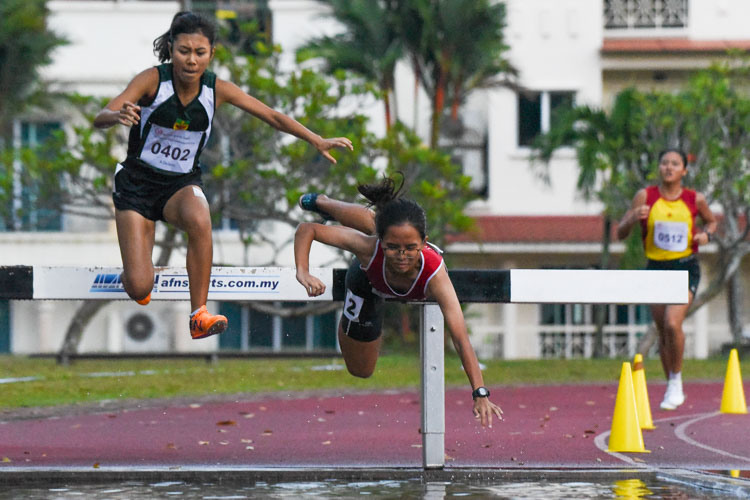 NJC's Ng Yu Ching (in red) suffered a bad fall on her second last water jump -- falling head-first into the pit -- which caused her to drop from second to fourth position. However, in a remarkable comeback, she picked herself up and outsprinted HCI's Tanya Kang on the final stretch of the race to snatch the bronze. (Photo 7 © Iman Hashim/Red Sports)