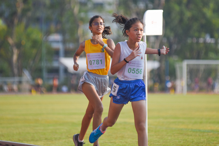 Natalie Tan (#556) of CHIJ St. Nicholas Girls' School finished second in 13:03.95, edging out Sofia Grewal (#781) of Cedar Girls' who finished third in 13:04.41. (Photo 2 © Iman Hashim/Red Sports)