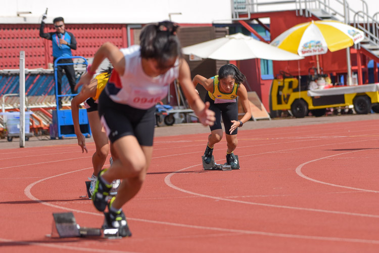 Emily Ong (in yellow) of SCGS bursts off her starting blocks. (Photo 2 © Iman Hashim/Red Sports)