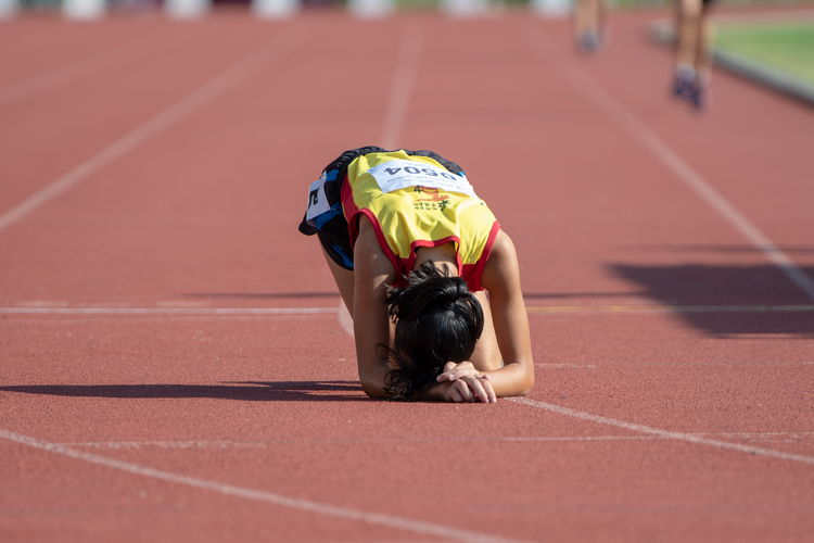 The 3000m A Divison Girls' final took its toll on Clarice Lau Jia Yun, who is seen here recovering after winning the race for HCI.