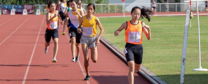 Cheyenne Lim Hwee Suan of SSP crosses the 1500m C Division Girls' final finish line less than a second ahead of runner-up Eryka Anna Kerner Pasupathy of CG (in yellow).