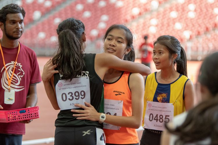 A Division Girls' 4x100m final runners briefly embrace after the race.