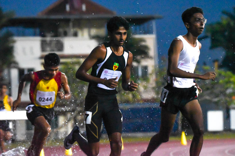 ASRJC's Ruben Loganathan, RI's Armand Mohan and HCI's Joshua Rajendran neck-and-neck during the initial race run on the evening of Monday, March 25 at Choa Chua Kang Stadium after a two-and-a-half-hours delay due to bad weather. The results for this race, however, were nullified after officials had mistakenly rung the bell one lap early. Armand and Ruben had sprinted to the "finish" in an exciting contest, before being told there was one more lap to go. Ruben and Joshua struggled through the actual last lap, while Armand dropped out. After appeals, the race was re-run three days later at the National Stadium. (Photo X © Iman Hashim/Red Sports)