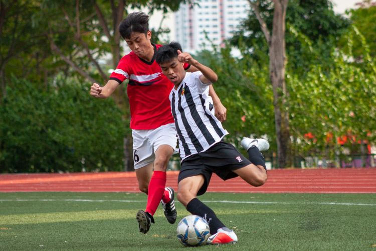 Ethan Lim (RI #5) gets the better of Nicholas Yap (NJC #6) as he prepares to pass the ball. (Photo 2 © REDintern Jordan Lim)