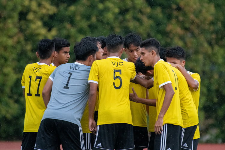 VJC players gather on the field for a team huddle before recommencing the second half after the lightning alert. While the alert had officially been ended, rain continued to fall.
