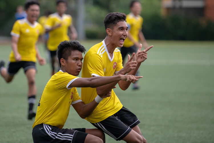 Haikel B Zaini (#11) and Umar B Sharin (#10) of VJC run up to VJC Photography Society members to pose for a photo after one of Haikel's goals.