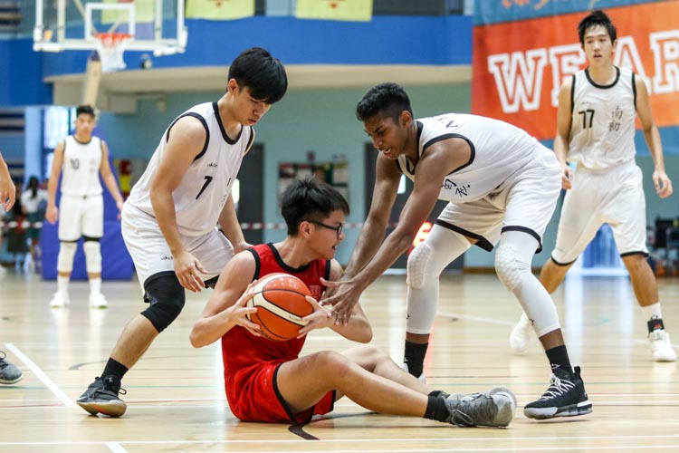 Chan Yu Cher (HCI #7) goes to ground while trying to protect possession. (Photo 8 © Clara Lau/Red Sports)