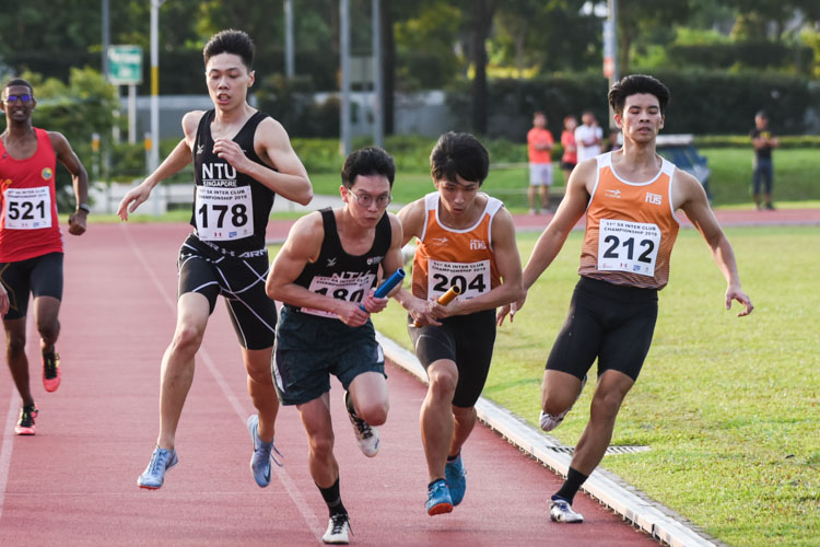 Justin Chan (#204) of NUS and Wayne Yap (#180) of NTU receive the baton almost simultaneously between the second and third legs of the Men's 4x400m Relay timed finals. NUS went on to win gold while NTU finished fifth. (Photo 1 © Iman Hashim/Red Sports)