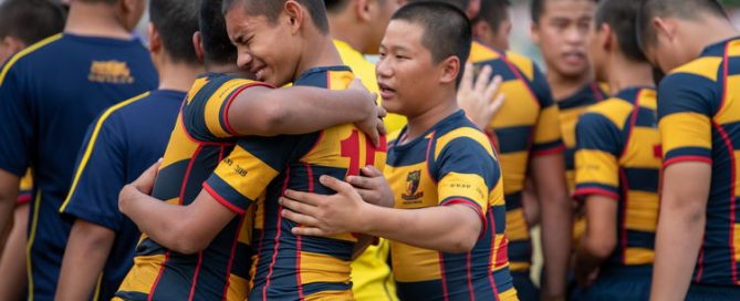 ACS(I) players hugging each other in tears as they celebrate their 19-7 victory over St Andrew's Secondary School in the C Division rugby Cup final. (Photo 1 © Jared Khoo/Red Sports)