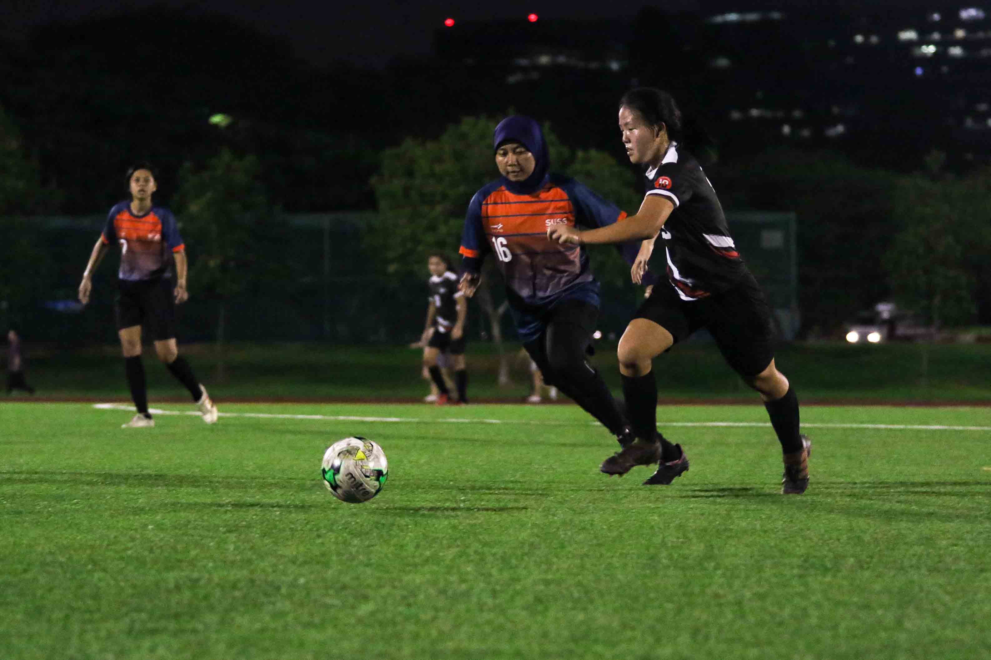 Winette Lim (SIT #13) attempts to dribble the ball past Izzati Safwanah (SUSS #16). (Photo 3 © Clara Lau/Red Sports)