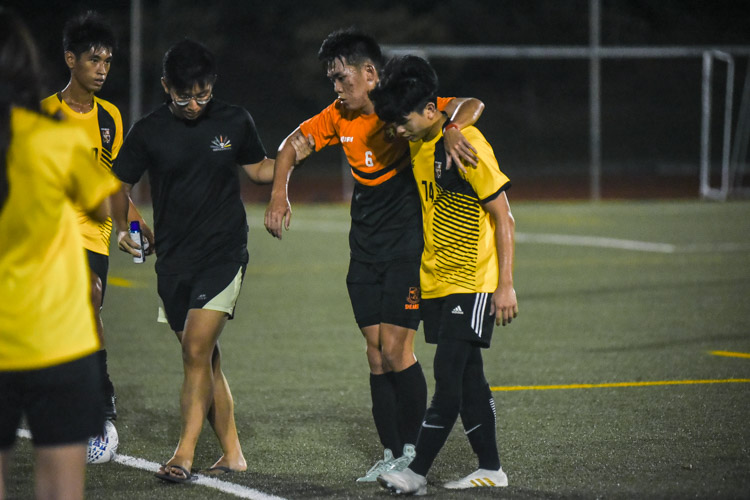 Tan Kay Shin (EH #74) helps opponent Tang Guang Yan (SH #6) off the pitch after the latter sustained an injury. (Photo 1 © Iman Hashim/Red Sports)