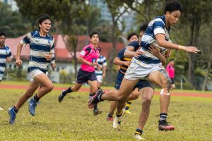 St Andrew's Gerald Yeo (right) carries the ball past the gain line. Anglo-Chinese School (Barker Road) Sub Team 1 pipped St Andrew’s Secondary Sub Team 1 by one conversion to win by 7-5 in the first of two 7-a-side matches in the 2022 B Division National School Games rugby second semi final. (Photo 1 © Bryan Foo/Red Sports)