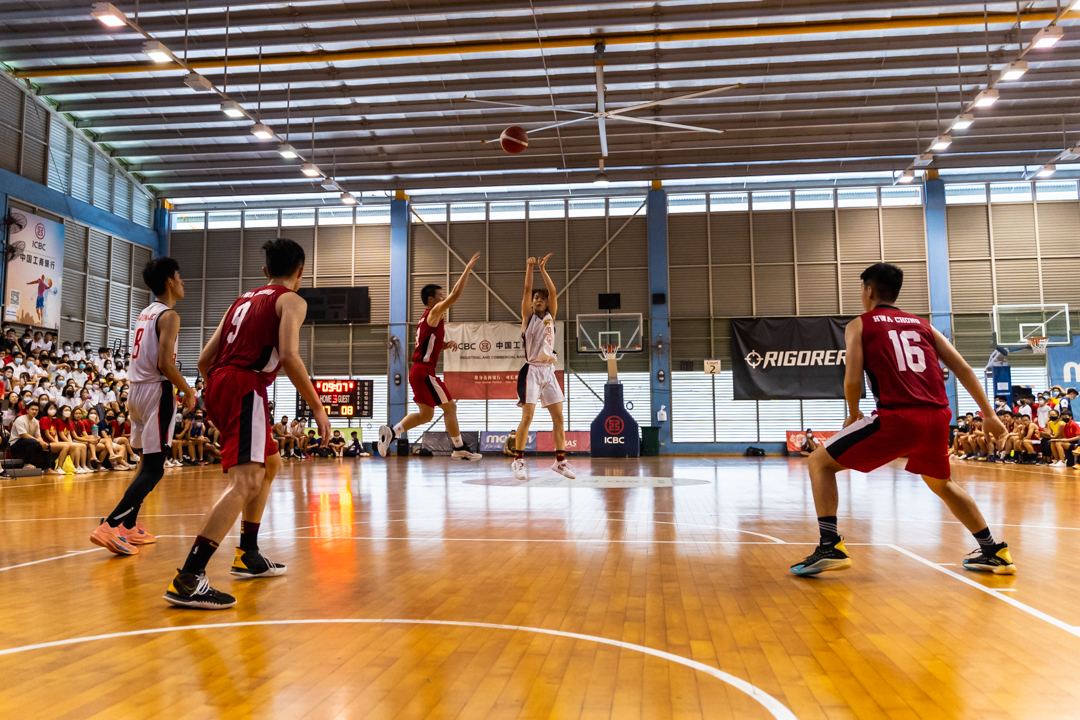 NJC player (centre, in white) takes a shot at a three-pointer. (Photo X © Bryan Foo/Red Sports)