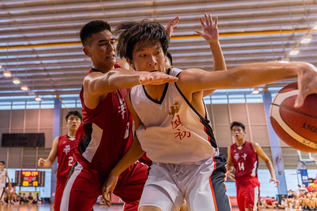 NJC's Liu Zhaofeng (right, in white) prevents the HCI defender from laying hands on the ball. (Photo X © Bryan Foo/Red Sports)