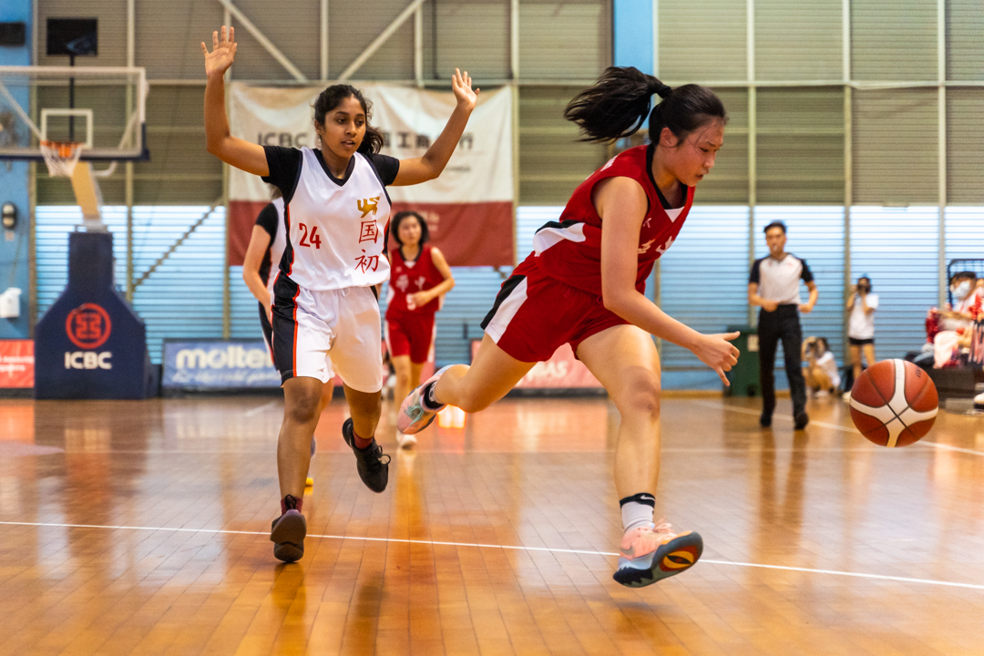 Sarah Goh (HCI #13) (right, in red) drives the ball to the opposition basket. (Photo X © Bryan Foo/Red Sports)