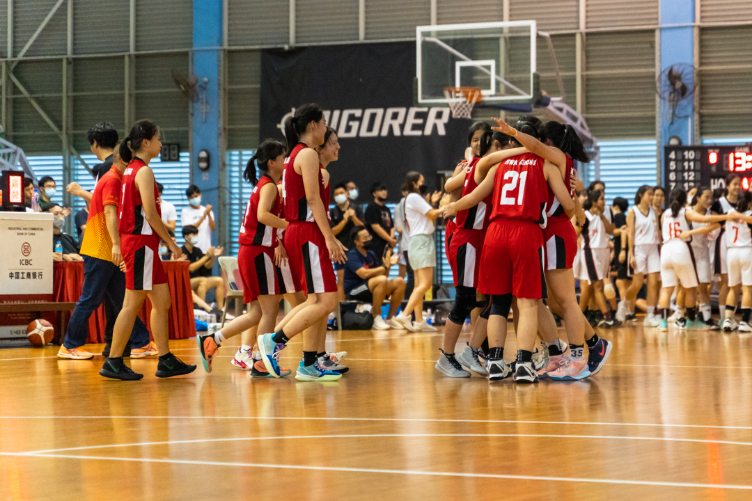 Hwa Chong Institution players rush onto court to embrace each other after winning their match. (Photo X © Bryan Foo/Red Sports)