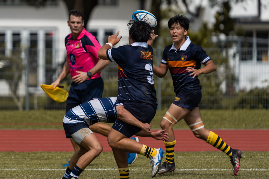 Anthony Ian Ng (#3) passes in the tackle to teammate Emilio Huang Zhong Min (#14).