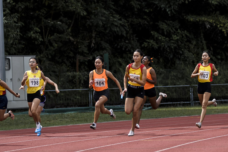 SSP's Tong Yan Yee (#164) and HCI's Eleana Goh (#85) run the second leg in the A Div girls' 4x100m relay final. (Photo 1 © Iman Hashim/Red Sports)
