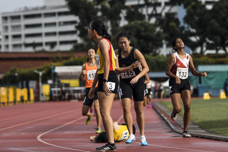 VJC's Mathilda Soh (#214) collapses onto the ground after finishing fourth in the A Div girls' 800m final, as RI's Regina (#148) crosses the line in fifth. (Photo 1 © Iman Hashim/Red Sports)