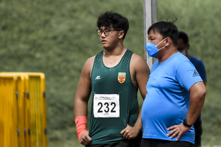 Aloysius Loh (#232) gets some words of advice from RI (Y5-6) throws coach Chen Jinlong, before his record-breaking effort. (Photo 1 © Iman Hashim/Red Sports)