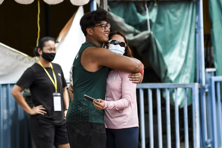 RI's Aloysius Loh (#232) embraces his mother, Tan Ying Yun, after setting a new championship record of 17.89m in the A Division boys' shot put (5kg). (Photo 1 © Iman Hashim/Red Sports)