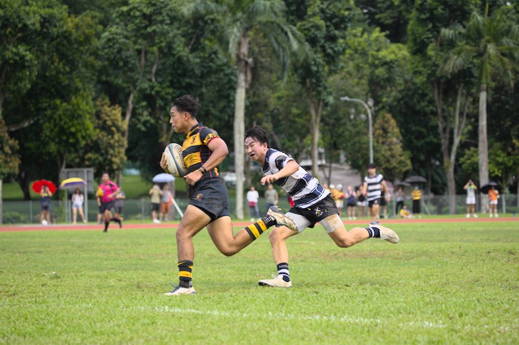 Tycen Yeoh outpaces Ian Lee Khang to score a try, after the penalty earned by teammate Braydon Yu.