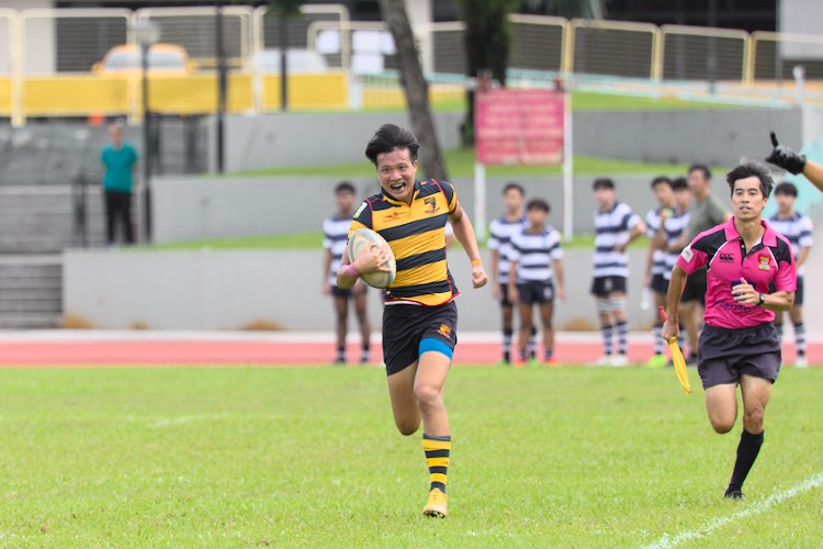 Ryan Lim races down the sideline to score the final try of the first match.
