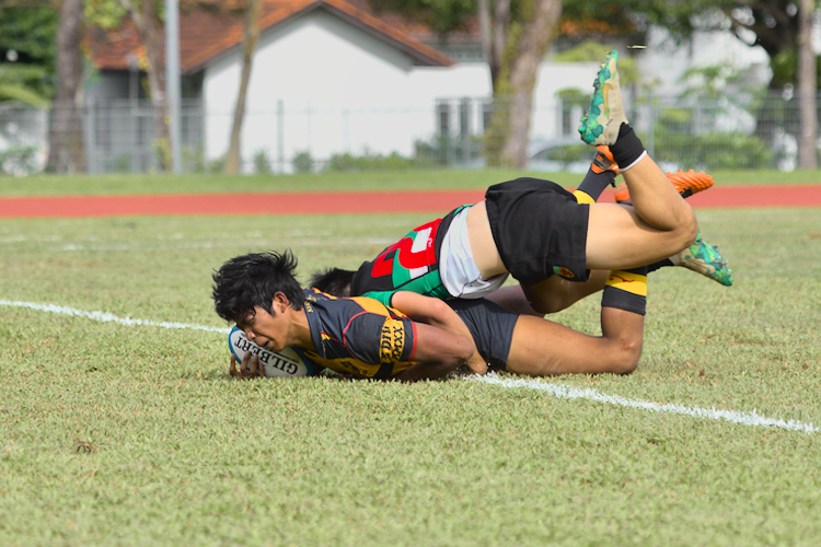 Anglo-Chinese School (Independent)'s Jeremiah Williams (in blue and gold) scores a try. (Photo 12 © Shenn Tan/Red Sports)