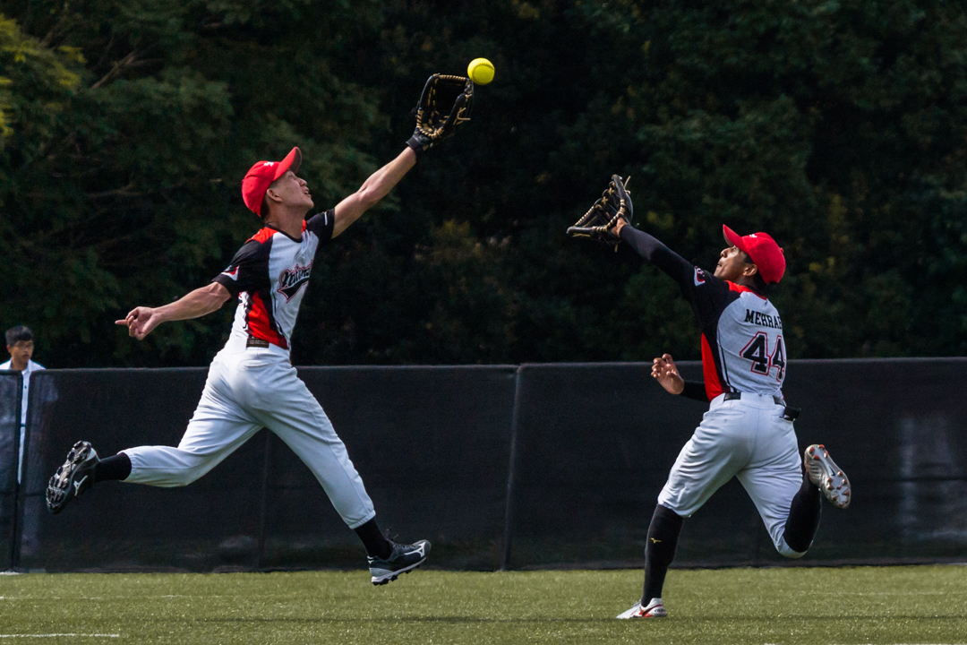 Outfielders Keegan (NJC #99) (left) and Mehrab (NJC #44) (right) attempt to catch the batted fly ball. (Photo X © Bryan Foo/Red Sports)