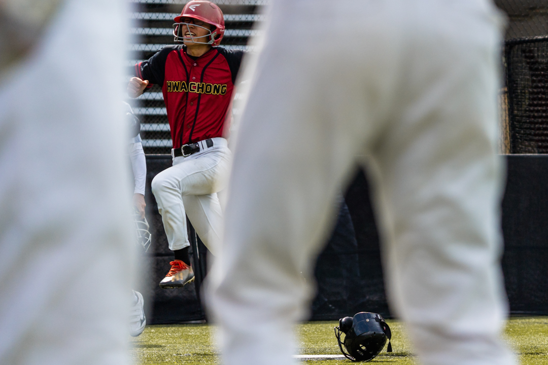 Evan (HCI #36) cracks a smile as he makes his way home, scoring a run for Hwa Chong. (Photo X © Bryan Foo/Red Sports)