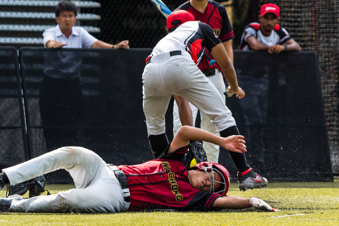 NJC pitcher Aniket (NJC #1) attempts to tag out the HCI runner. (Photo X © Bryan Foo/Red Sports)