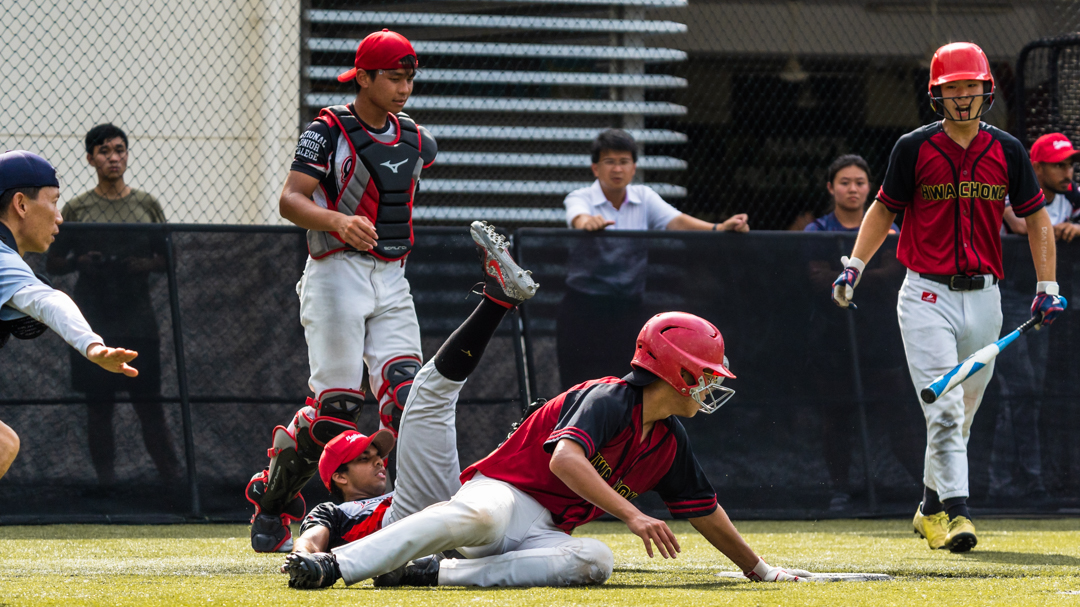 HCI player makes it home to score a run as the umpire calls "safe". (Photo X © Bryan Foo/Red Sports)
