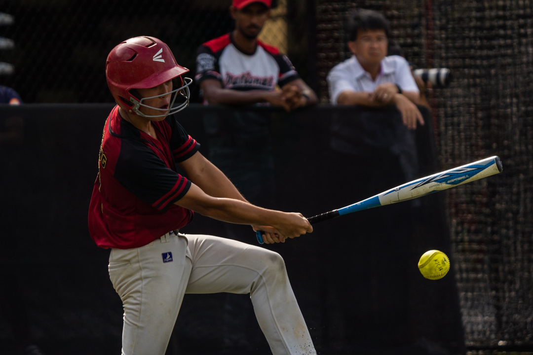 HCI third baseman Jun Heng (HCI #14) hits a grounder. (Photo X © Bryan Foo/Red Sports)