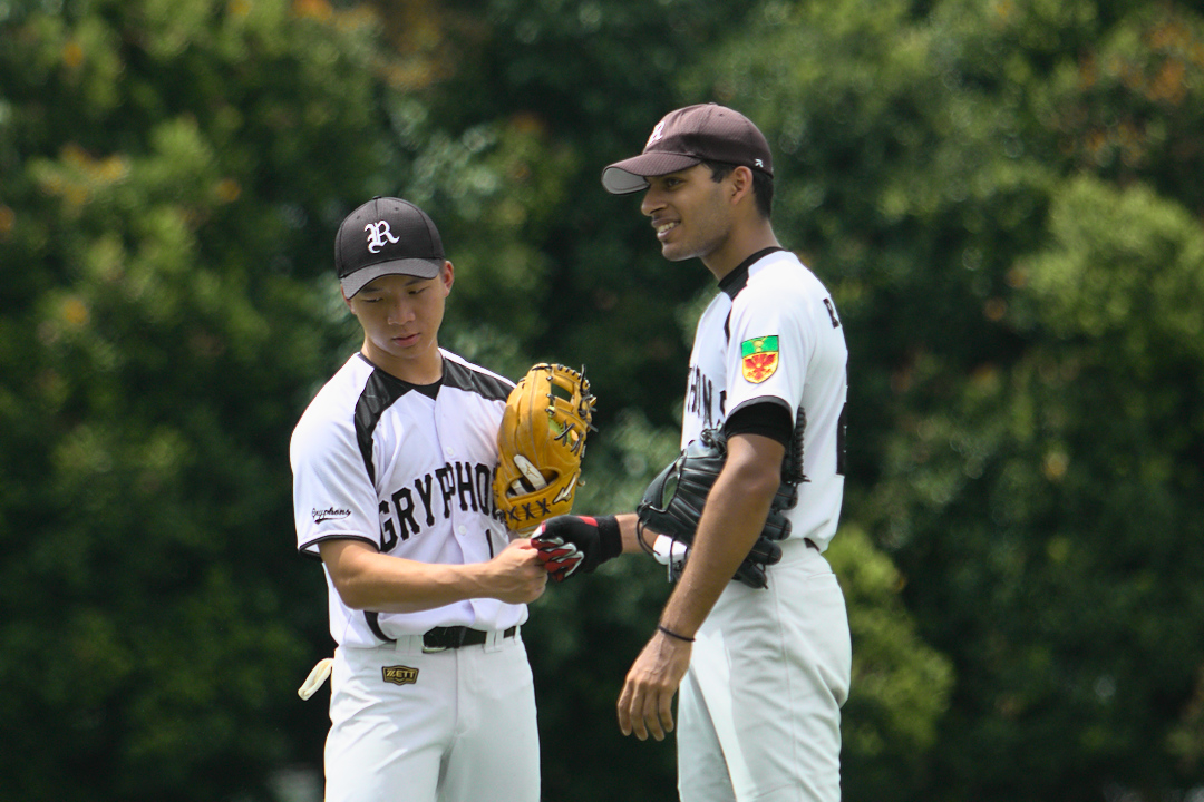 Shawn Yip (#1) bump fists with teammate Nayan (#25) during a break in play.